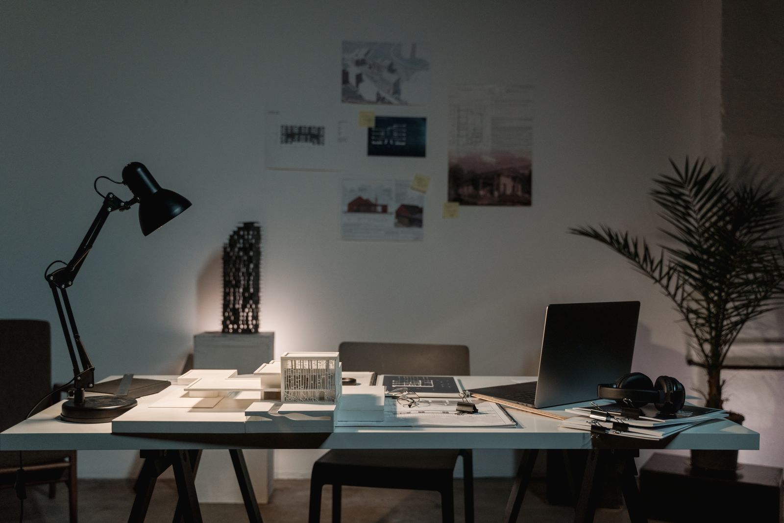 Property analysis workspace with plans, architectural model, and laptop